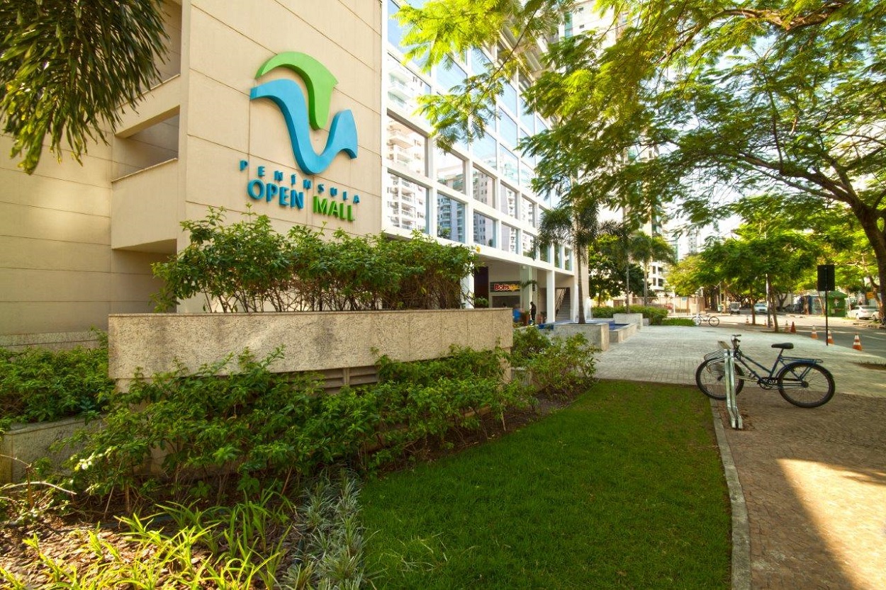Fachada do Peninsula Open Mall com lojas e conveniências