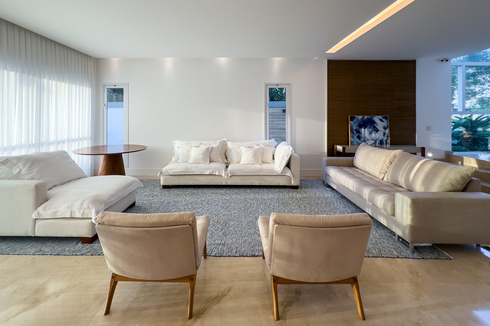 Sala de estar com sofás brancos e iluminação natural