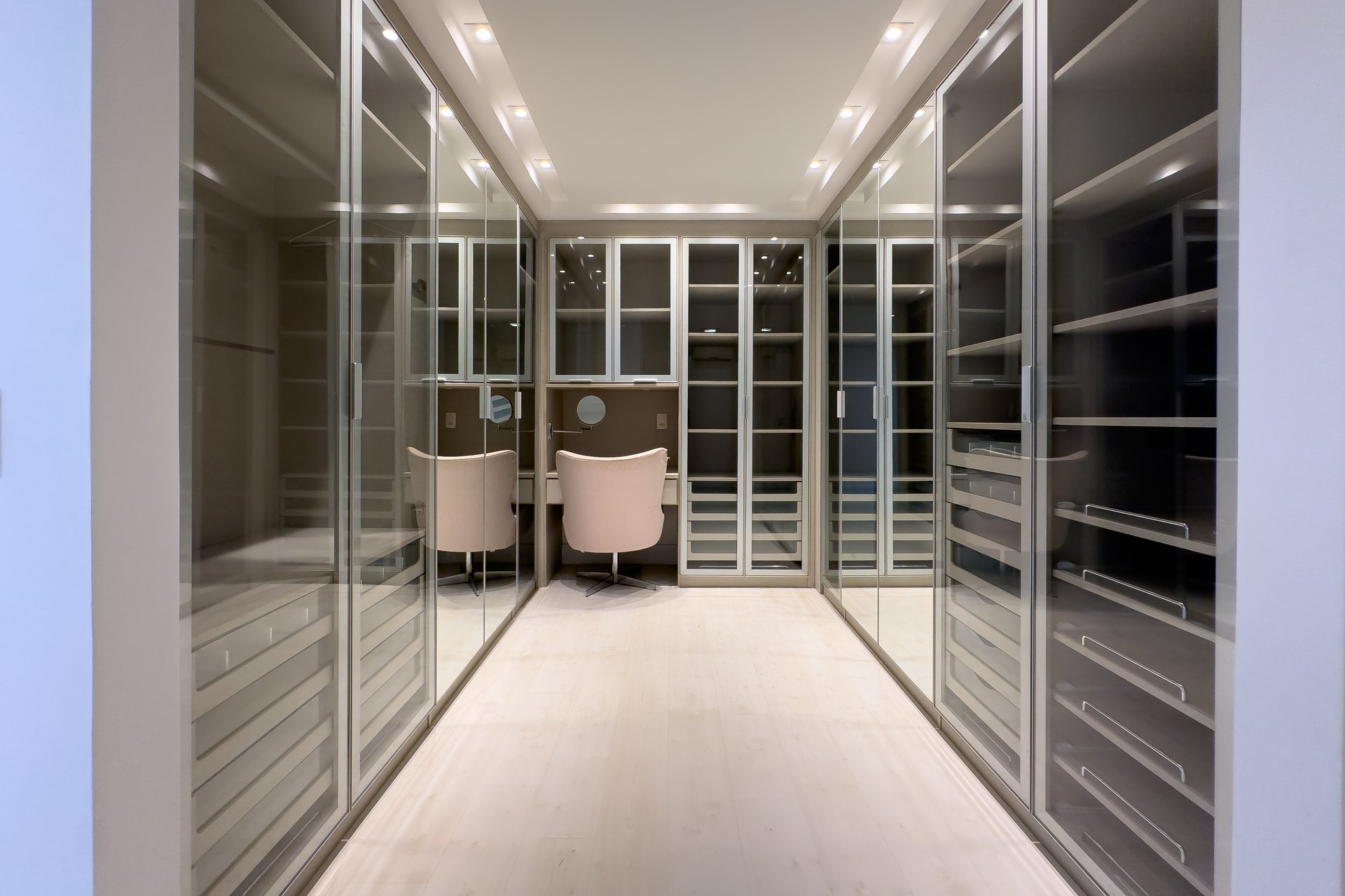 Closet amplo com espelhos e iluminação